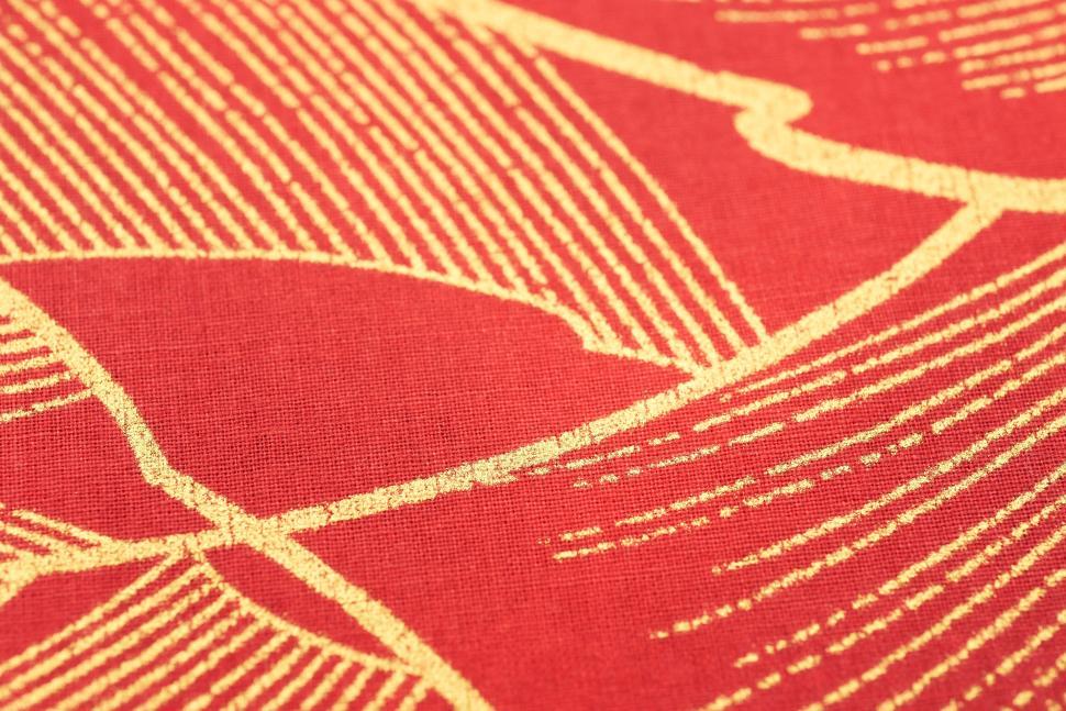 Free Image of Abstract geometric gold lines on red fabric detail 