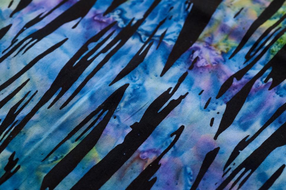 Free Image of Tie-dye fabric with black abstract streaks and color swirls 