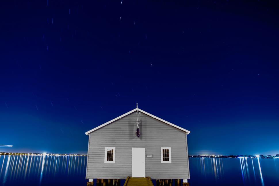Free Image of Small house on dock over water during night time. 