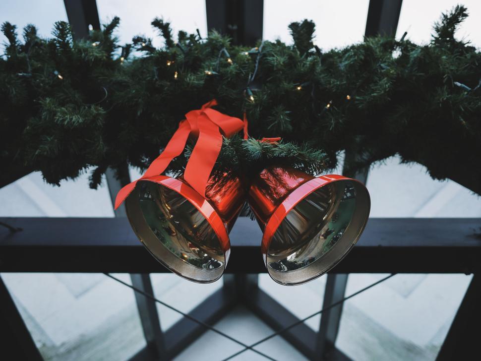 Free Image of Red Christmas bells with festive greenery and red ribbons. 