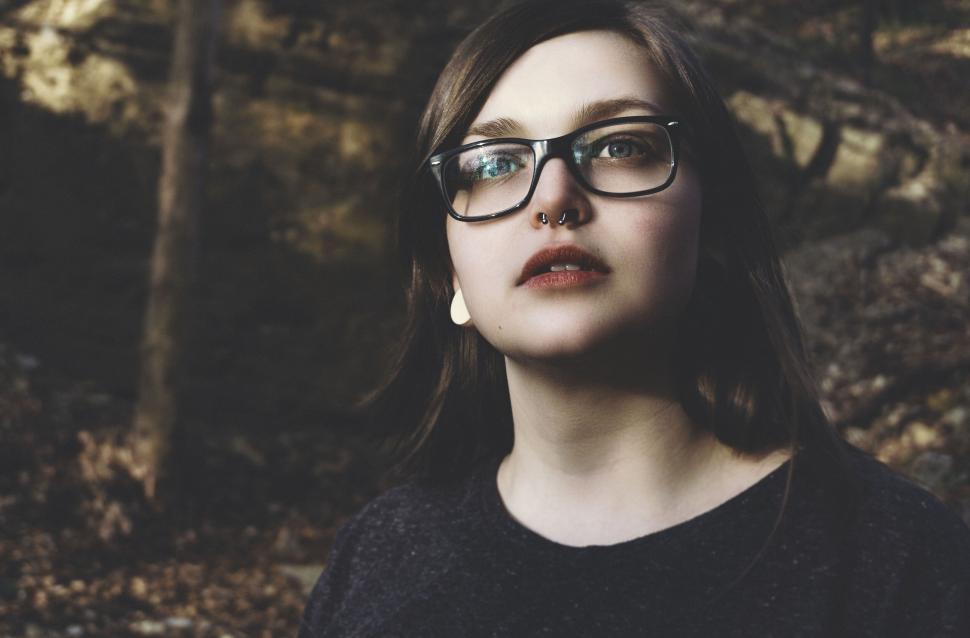 Free Image of Young woman with glasses and piercing in natural setting 