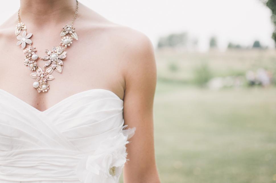 Free Image of Elegant bride wearing white dress with pearl necklace 