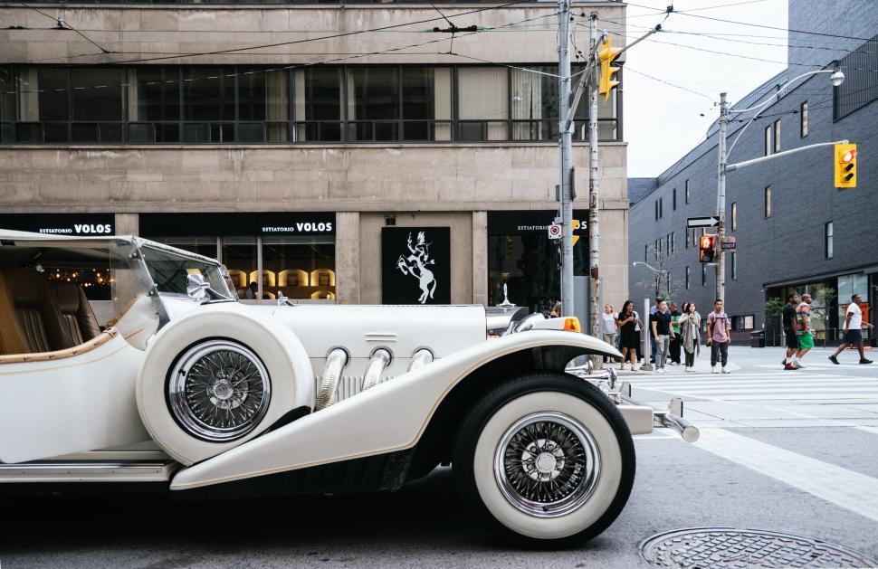 Free Image of Vintage car parked on a busy urban street corner 