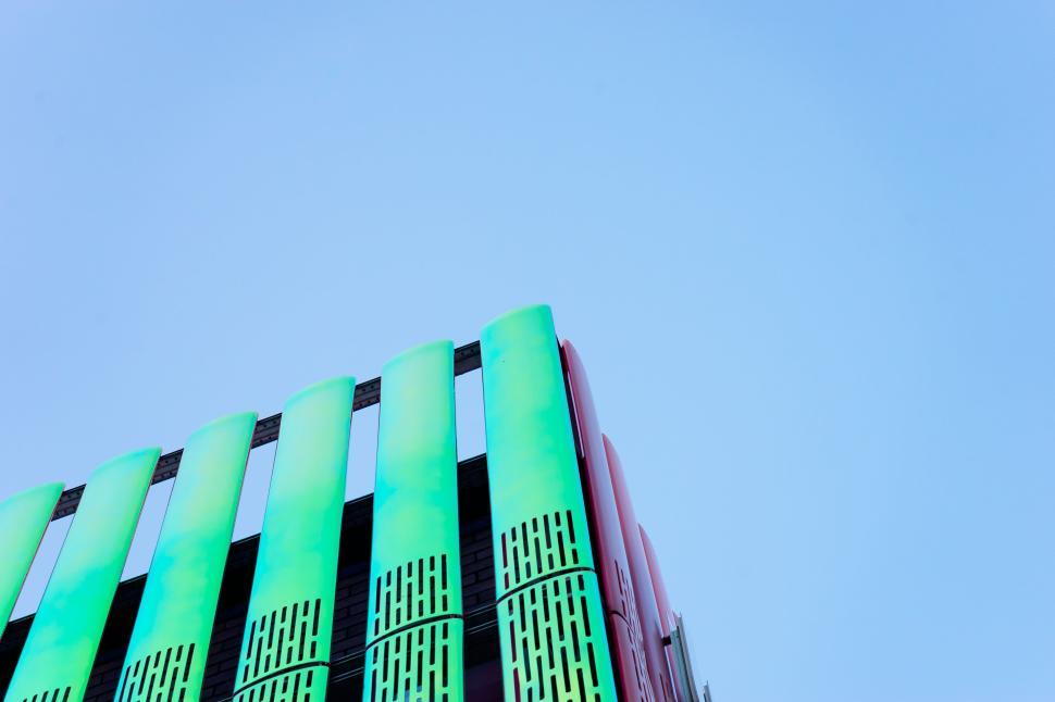 Free Image of Green vertical slats on modern building against blue sky 
