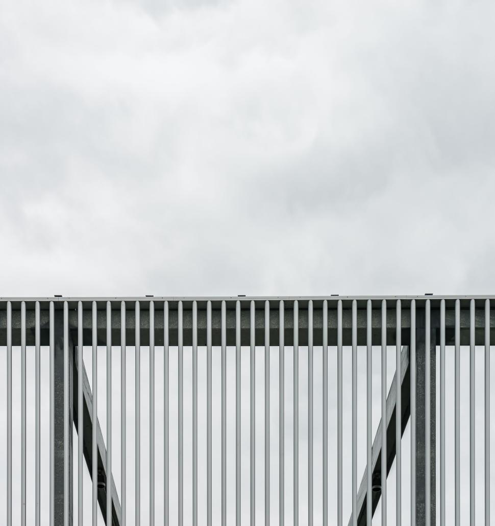 Free Image of Metal bars against cloudy sky architectural view 