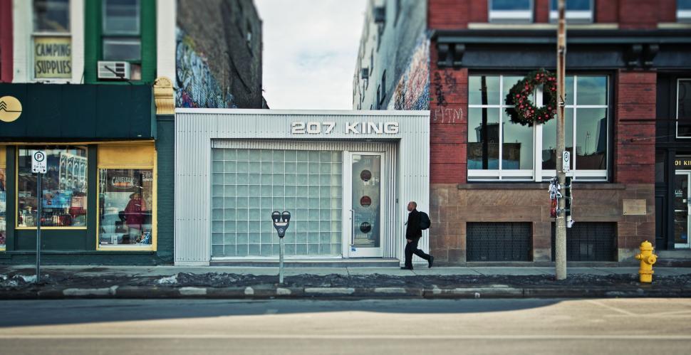 Free Image of Urban street view featuring a man and a modern storefront 