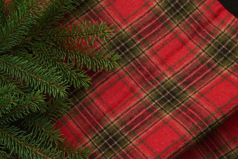 Free Image of Red and green plaid fabric with pine needles 