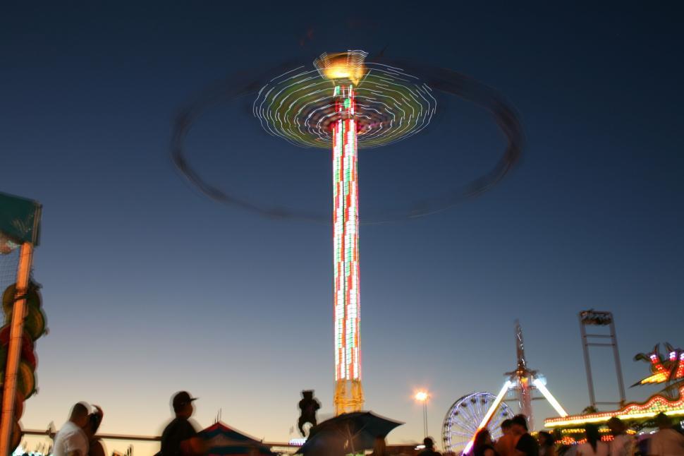 Free Image of Colorful amusement park ride spinning at dusk time 