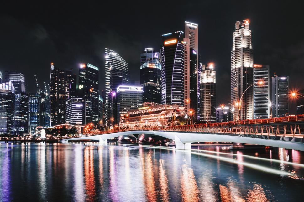 Free Image of Nighttime cityscape featuring illuminated skyscrapers and bridge 