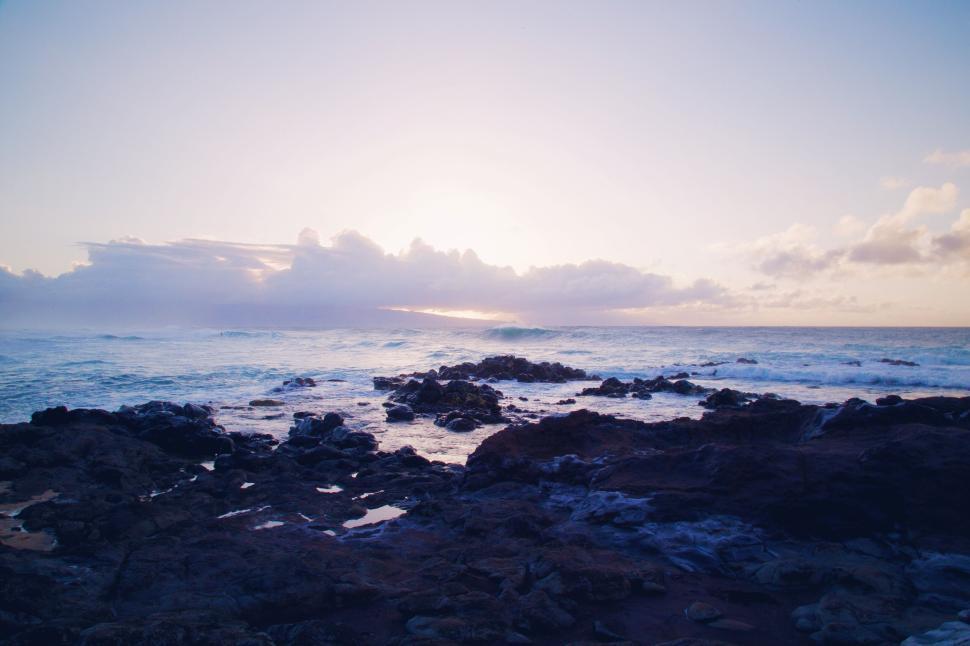 Free Image of Calm seaside during sunset with rocky shoreline 