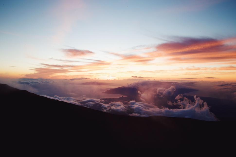 Free Image of Sunset view from a high altitude with clouds below. 