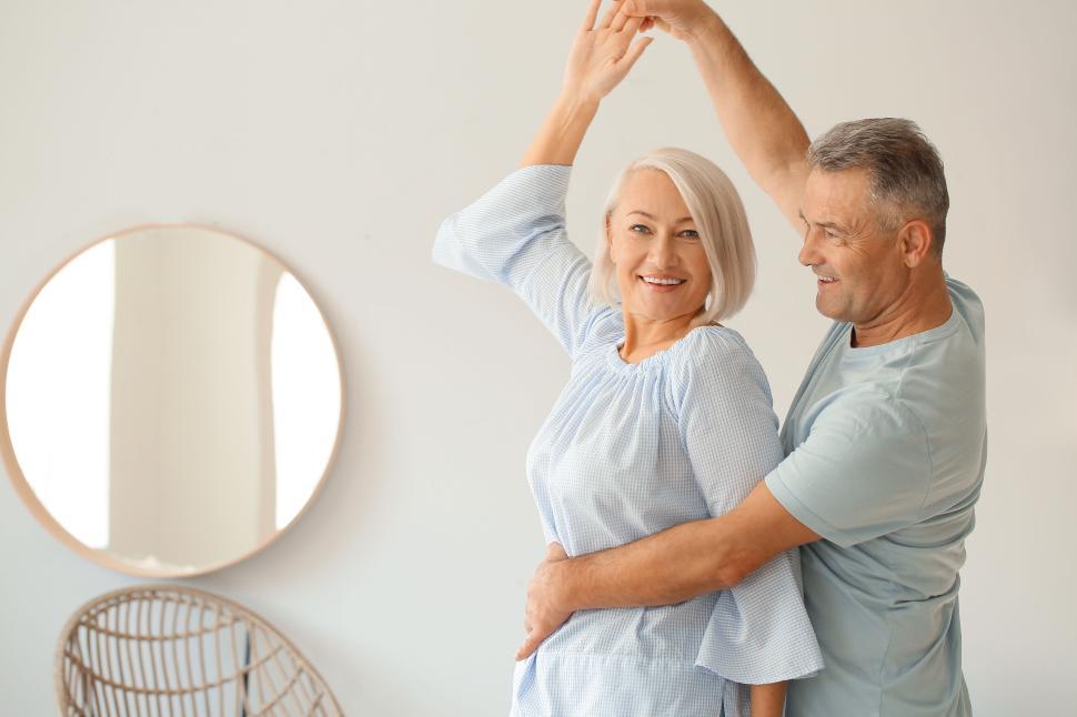 Free Image of Elderly couple dancing joyfully in their living room. 