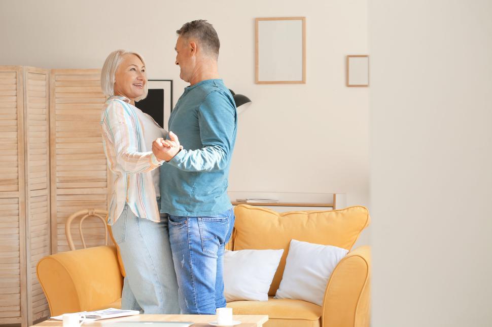 Free Image of Elderly couple dancing at home in a light-filled space. 