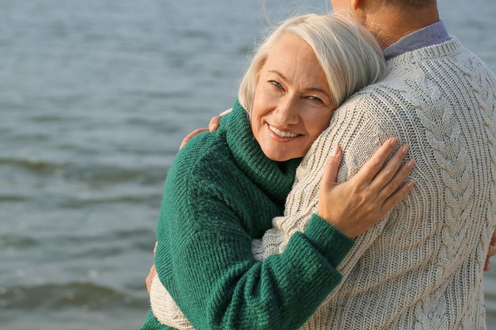 Free Image of Elderly couple hugging affectionately by the seaside. 