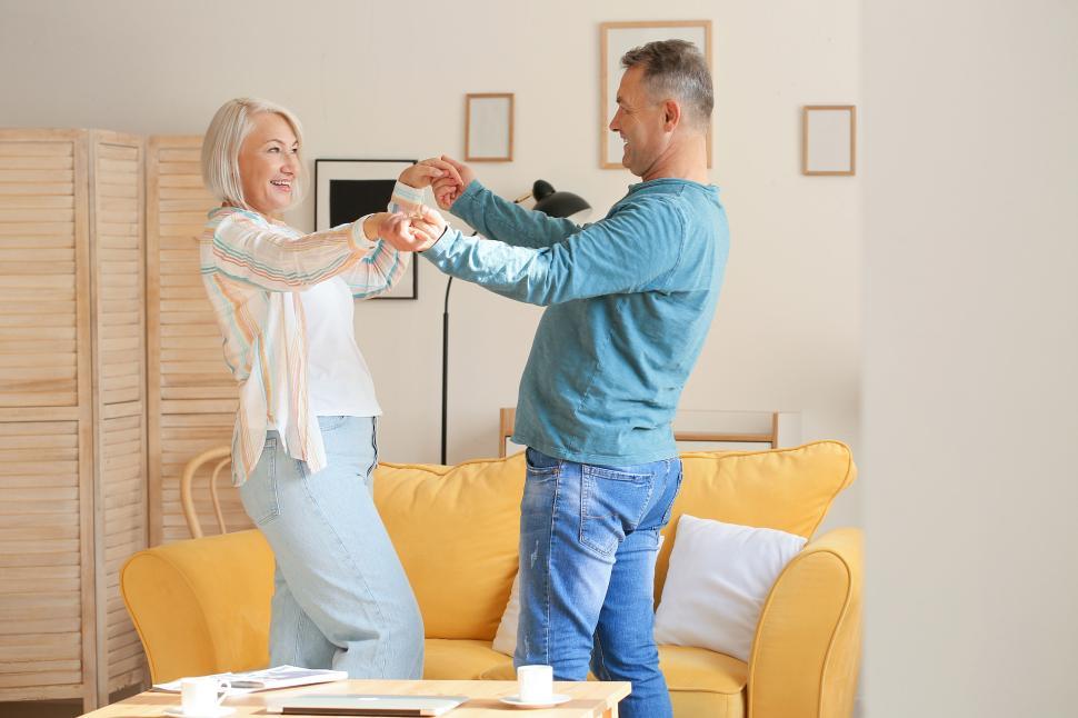 Free Image of Elderly couple dancing joyfully in the living room 