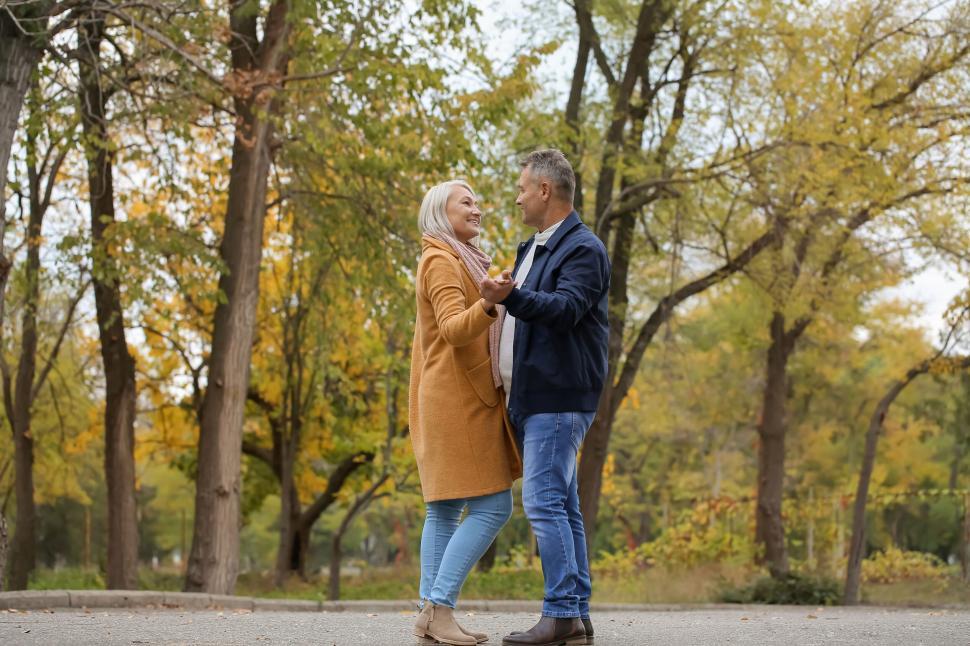Free Image of Elderly couple dancing happily in a beautiful park 