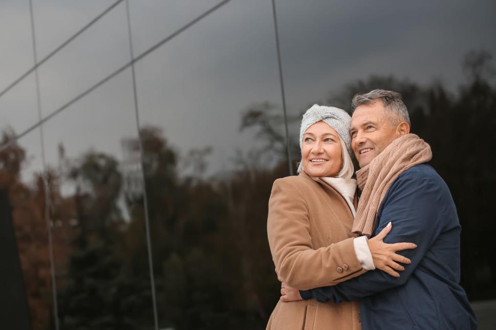 Free Image of Happy older couple hugging in warm autumn clothes outside. 