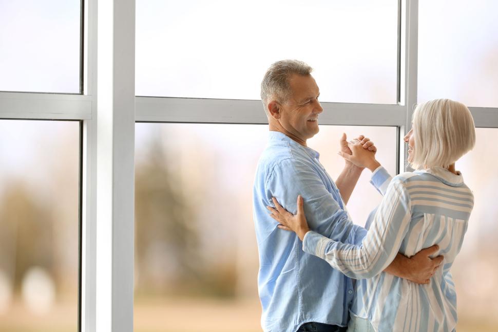 Free Image of Older couple joyfully dancing together in their home 