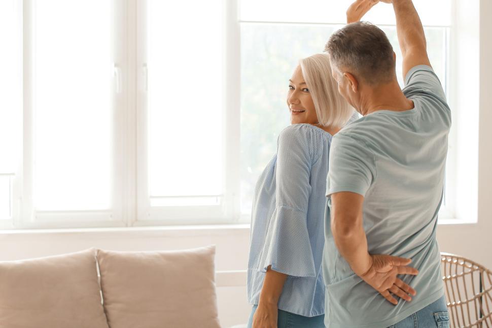 Free Image of Older couple enjoying a dance together at home indoors. 