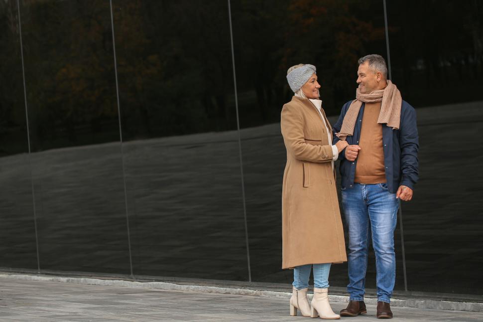 Free Image of Elegant older couple walking together in fall attire. 