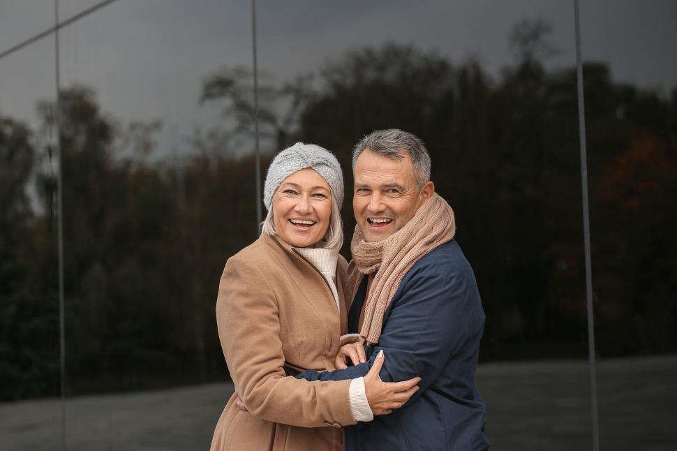 Free Image of Older couple bundled up embraces outdoors warmly. 
