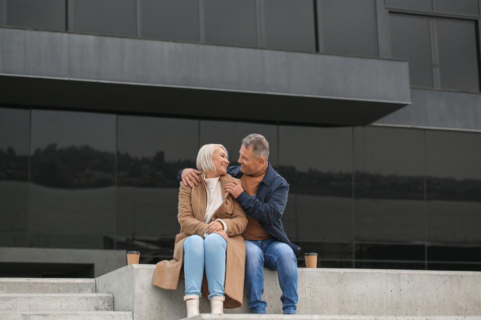 Free Image of Happy elderly couple hugging on concrete steps. 