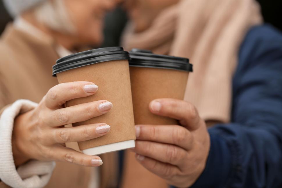 Free Image of Couple Toasting with Coffee Cups Close to Each Other Outdoors 