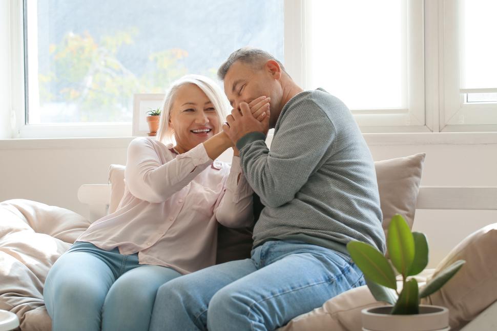 Free Image of Happy couple shares playful moment on couch at home. 