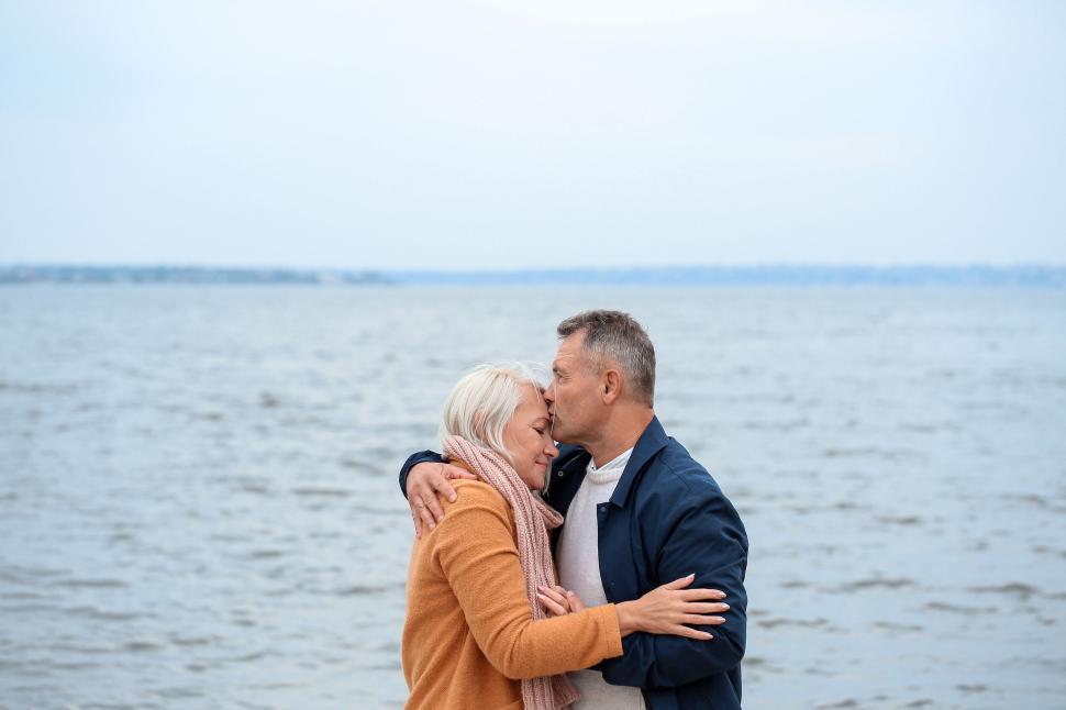 Free Image of Senior couple embracing for a kiss by the water 