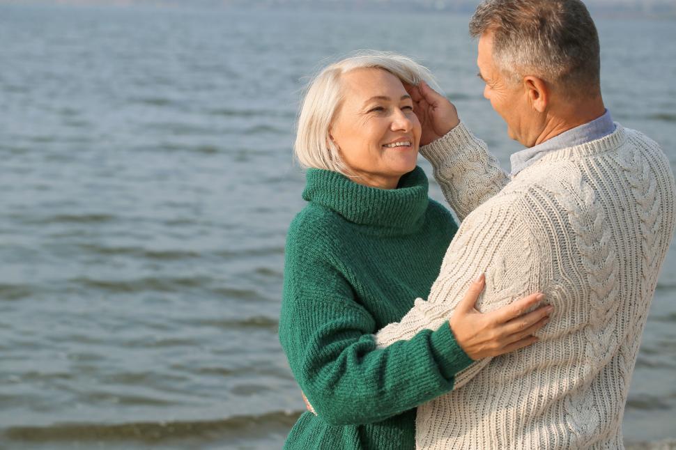 Free Image of Senior couple embracing by the sea, smiling warmly. 