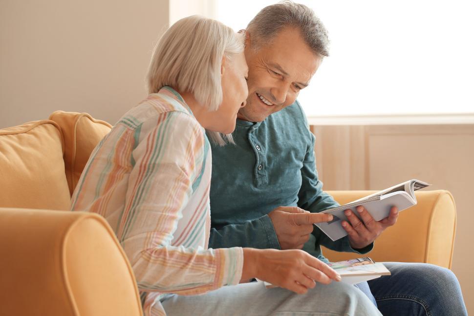 Free Image of Couple reading a book together on a cozy couch 
