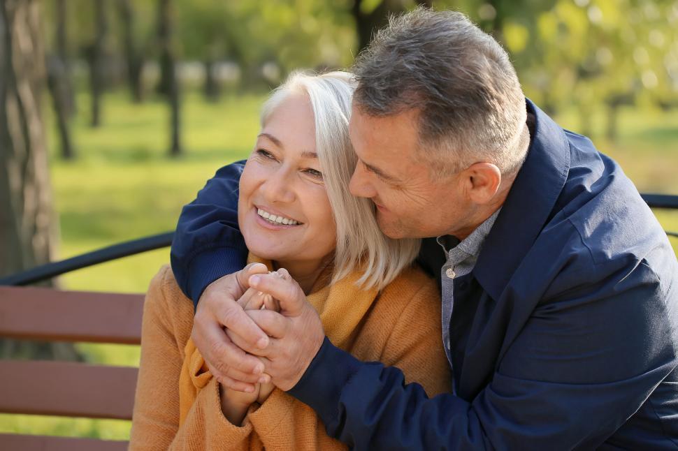 Free Image of Elderly couple cuddling on a park bench in love 