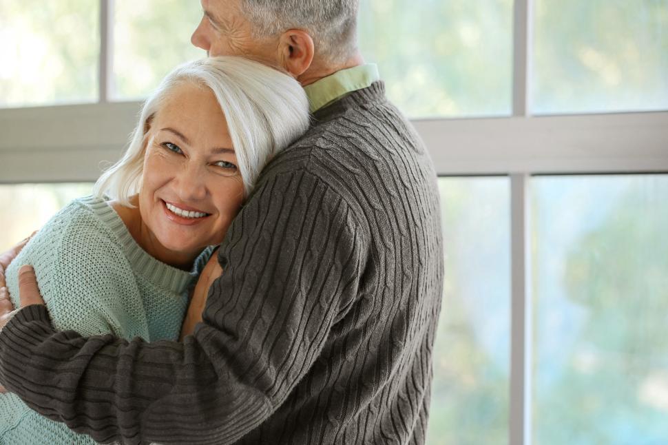 Free Image of Elderly couple hugging inside a cozy home setting 