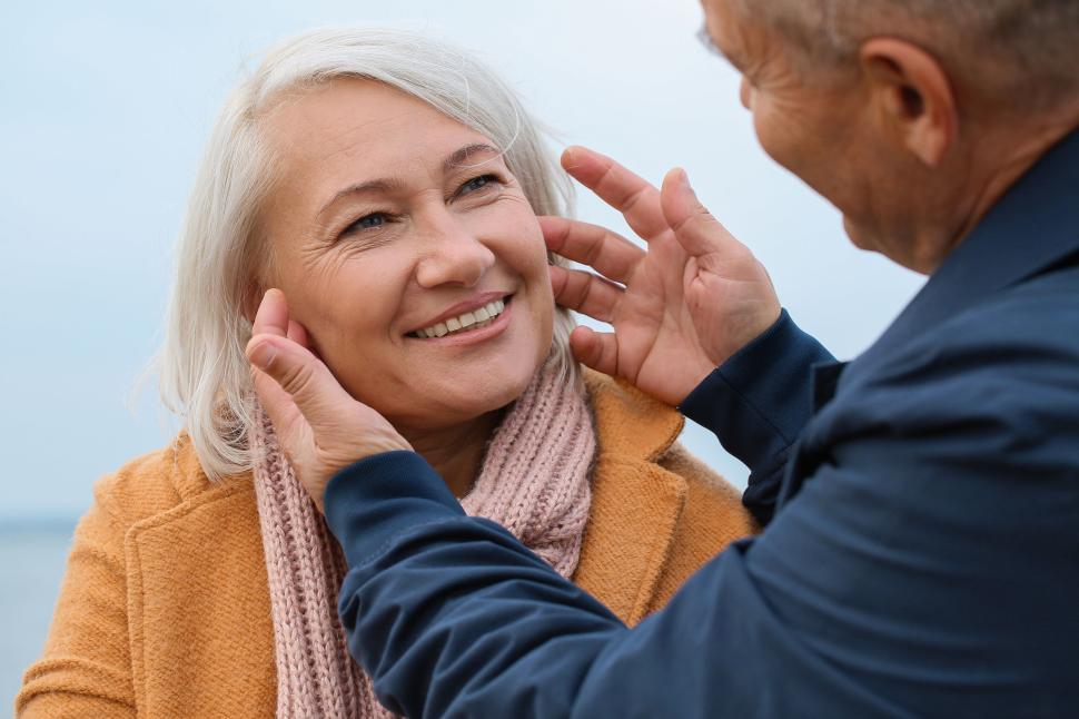 Free Image of Elderly couple sharing a warm moment by the river 