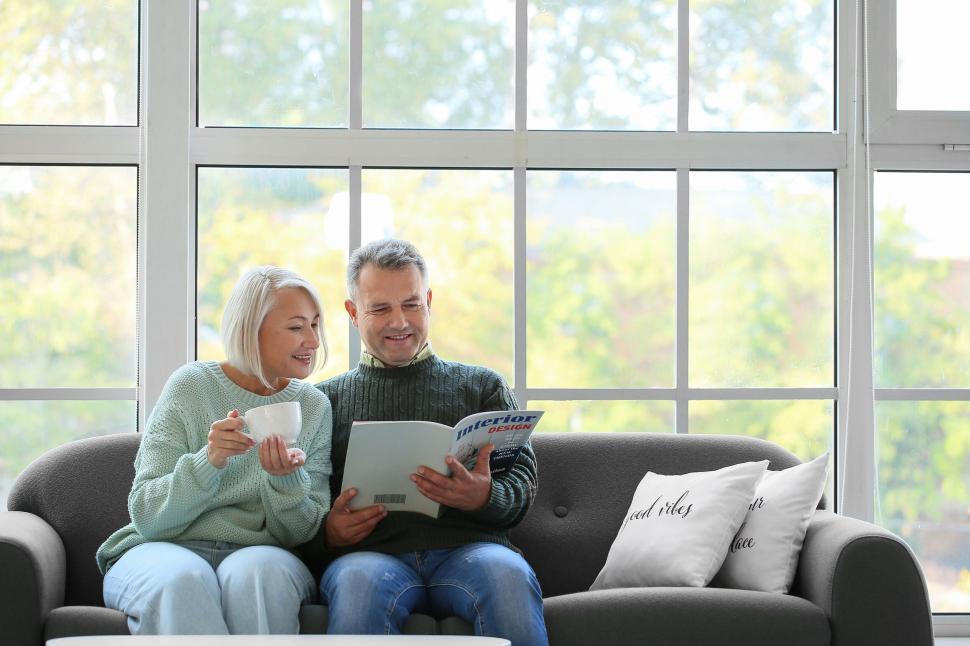 Free Image of Cozy couple reading and sipping by a bright window 