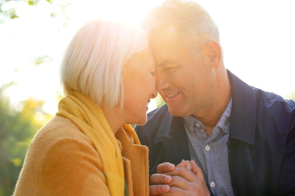 Free Image of Elderly couple embracing on sunny day in autumn park 