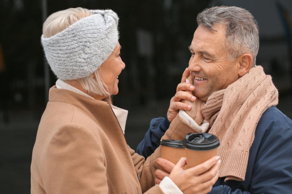 Free Image of Couple enjoying warm beverages while sharing gaze. 