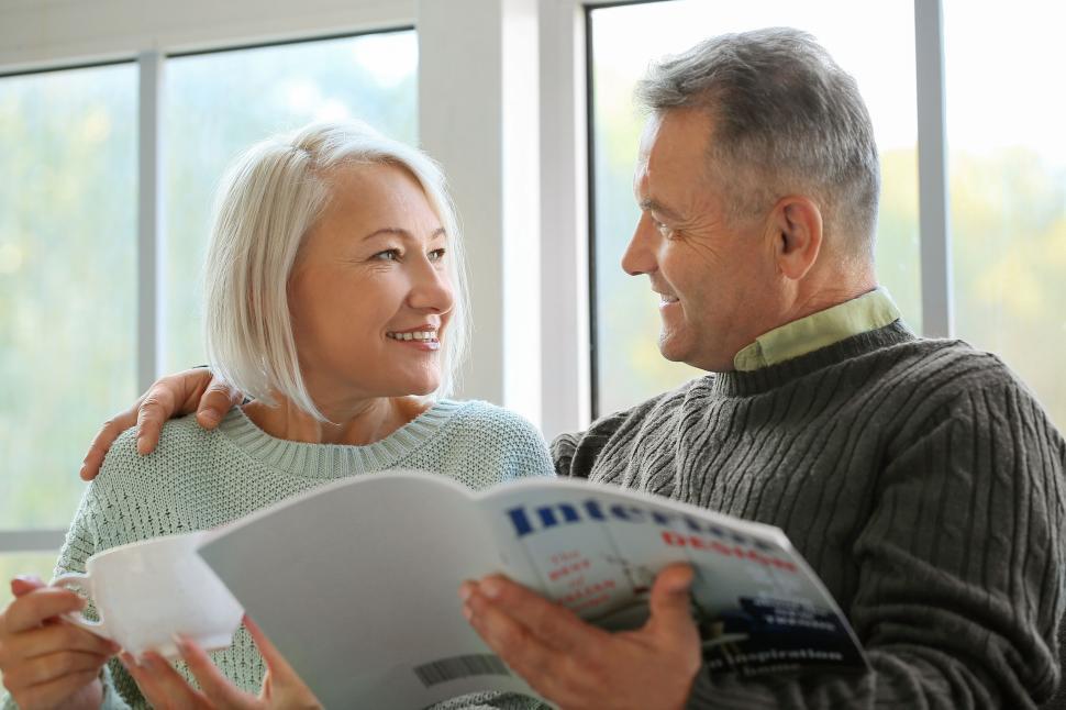 Free Image of Man and woman reading magazine with joy. 