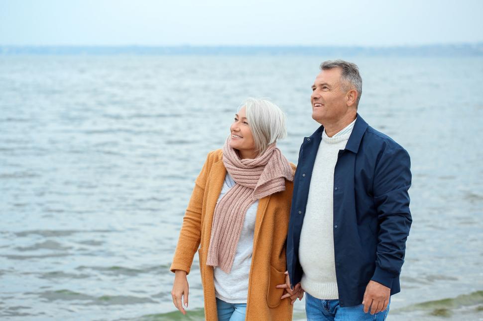 Free Image of Happy couple enjoying a walk by the sea coast together 