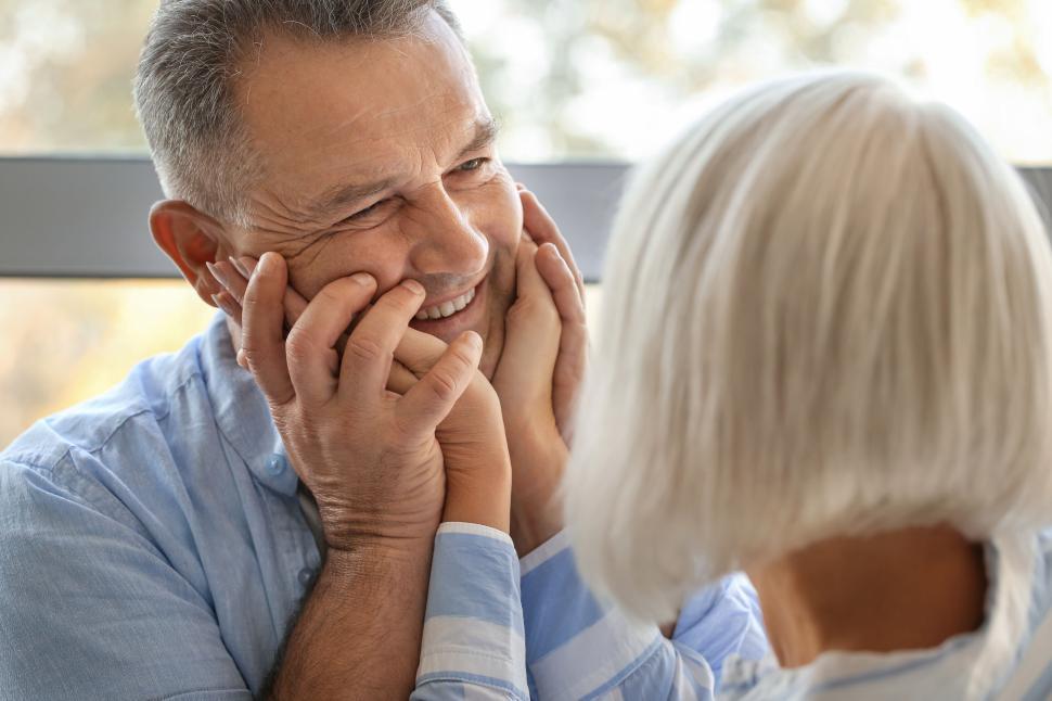 Free Image of Elderly couple holding hands, sharing a loving gaze 