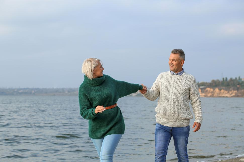 Free Image of Loving couple enjoying a walk along the shoreline 