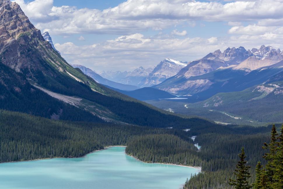 Free Image of Turquoise lake nestled between forested mountain valleys 