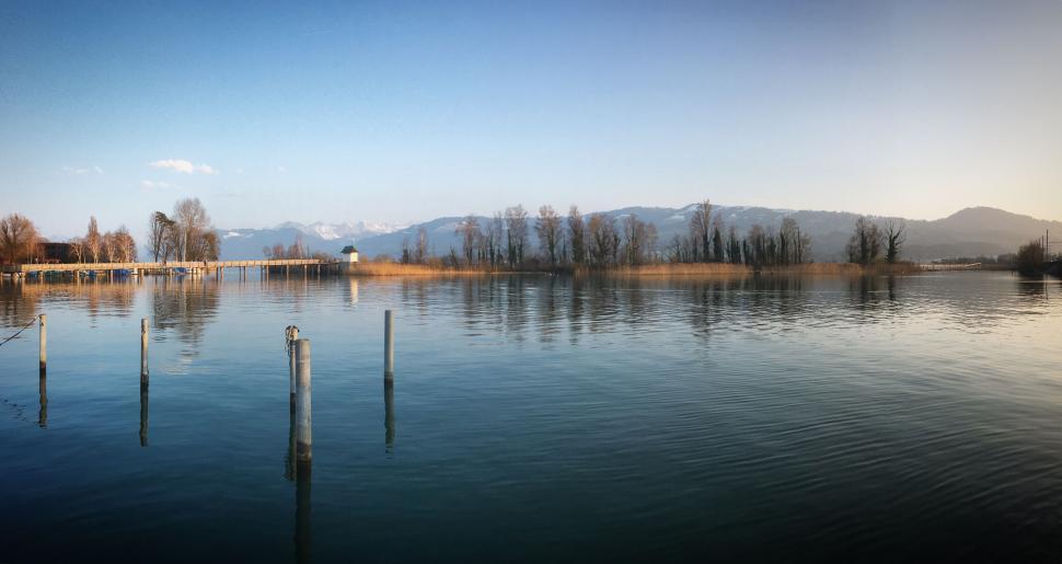 Free Image of Reflection of trees and mountains in calm lake water. 