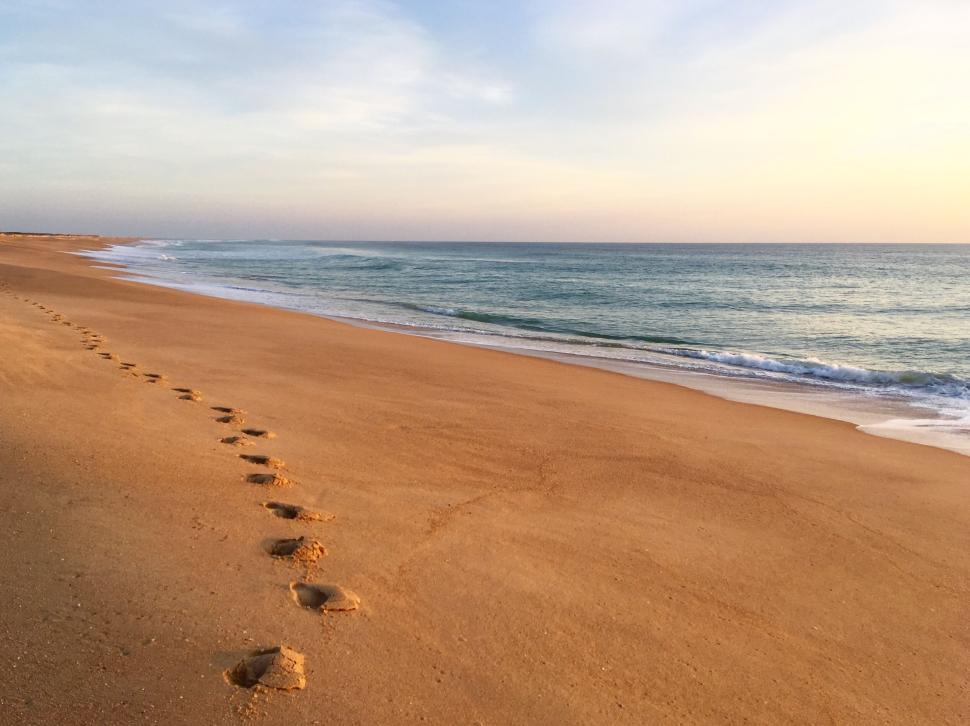 Free Image of Bright sandy beach with single set of footprints. 