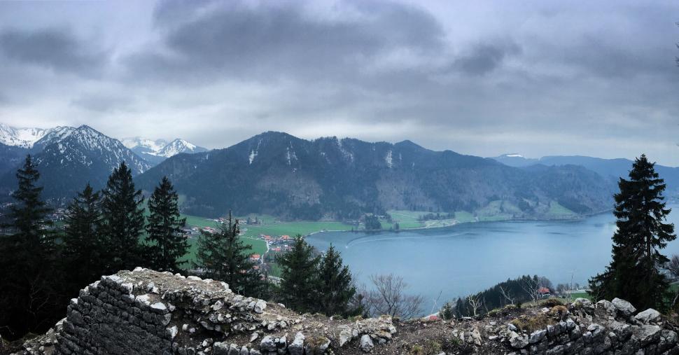 Free Image of Overlooking valley and lake amid mountains under gray sky 