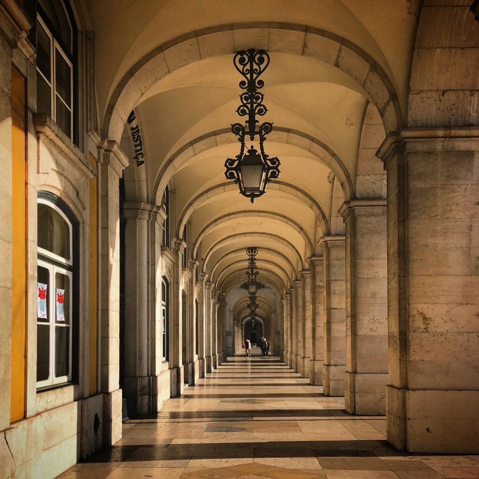 Free Image of Arched corridor with ornate lights leading to bright exit 