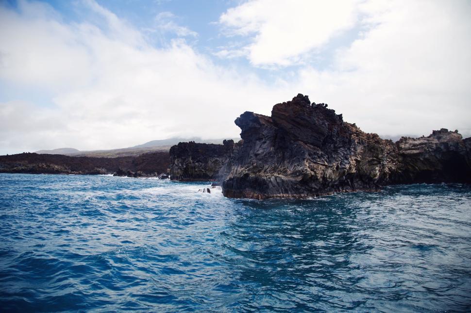 Free Image of Rocky coast and blue ocean under the clear sky 
