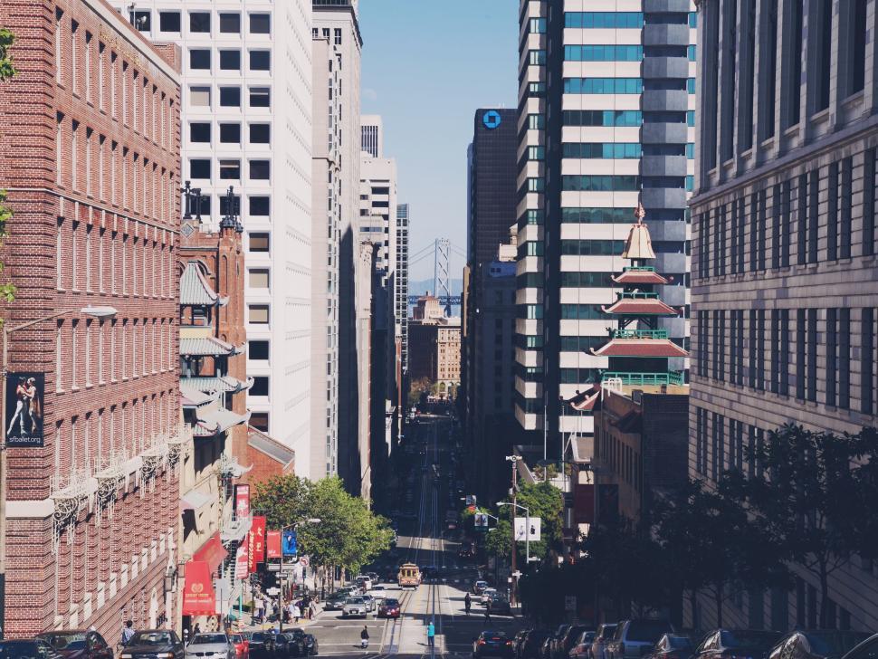 Free Image of Downtown city street with skyscrapers and cable car 