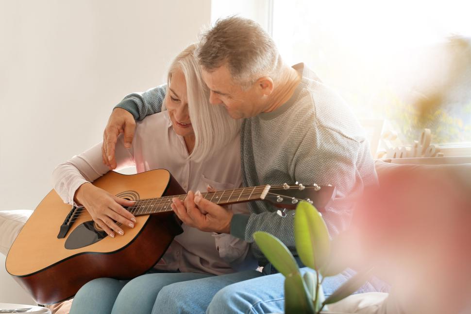 Free Image of Elderly couple sharing a tender moment with guitar. 