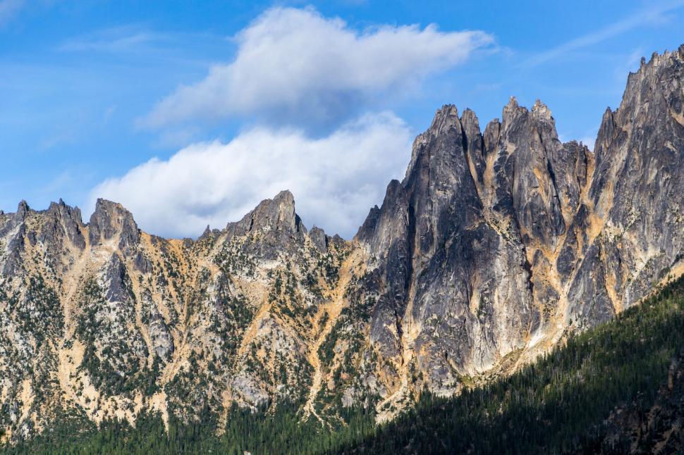 Free Image of Rugged mountain peaks under a partly cloudy sky 